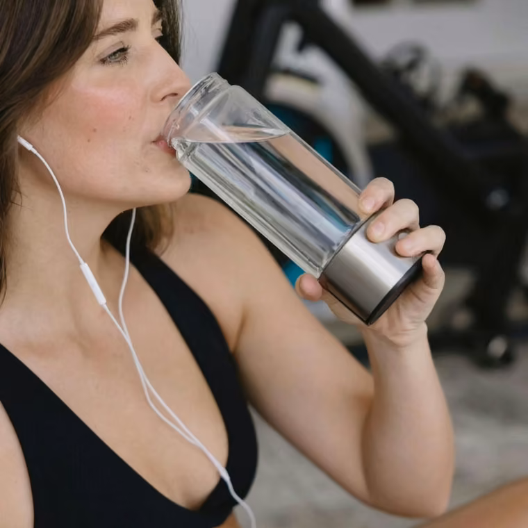 Woman drinking Aquivor hydrogen water during her workout